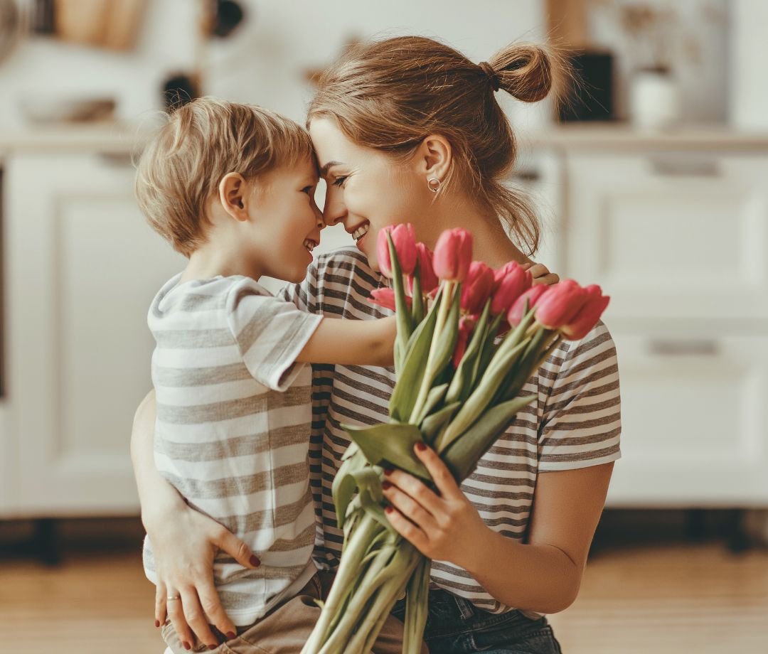 Mamá abrazando a su hijo con amor mientras comparten un momento especial en casa.